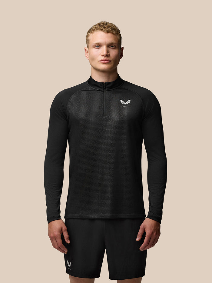 Male model wearing black Adapt Training 1/4 Zip Top with stand collar, geometric pattern and Castore branding on the chest.