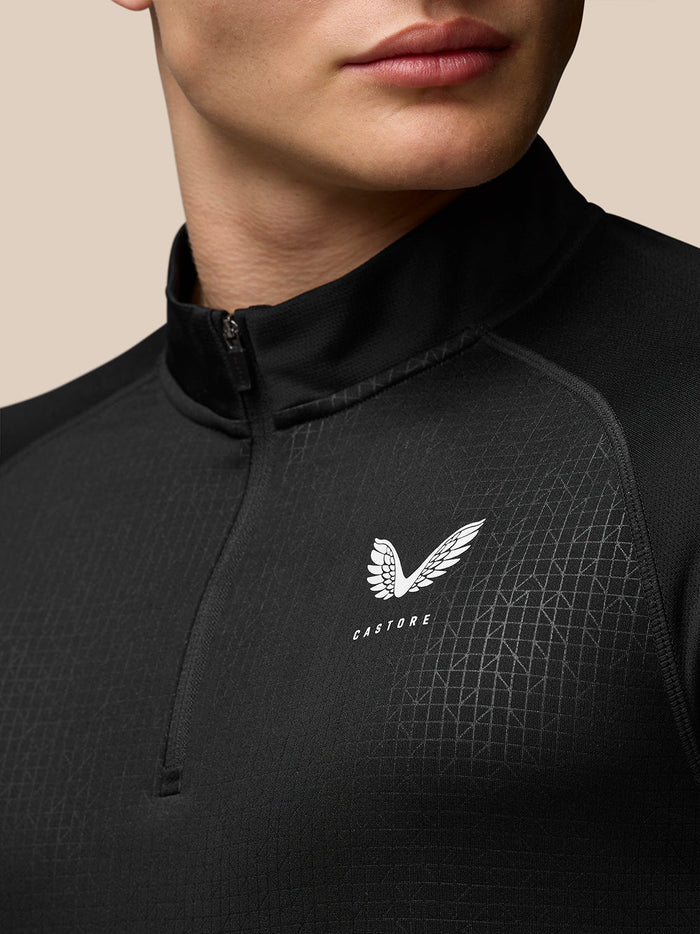 Close up of black Adapt Training 1/4 Zip Top showing stand collar geometric pattern and Castore logo on the chest