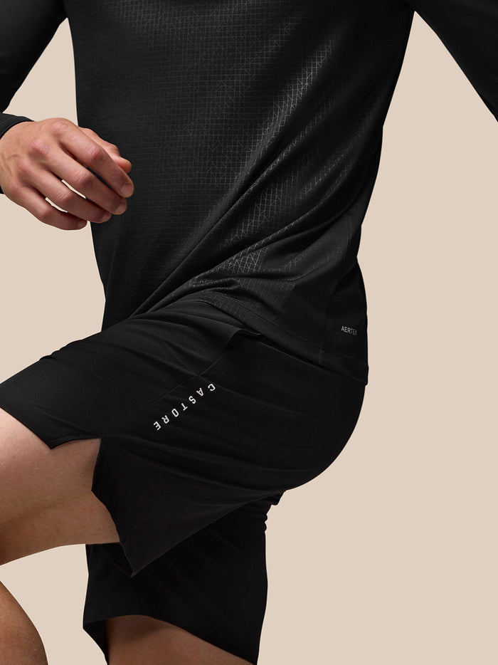 Back view of black Adapt Training long sleeve top with all over geometric texture and Aertek branding at lower back