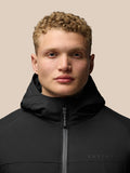 Close up of model wearing hooded black jacket with zipper and Castore branding on chest