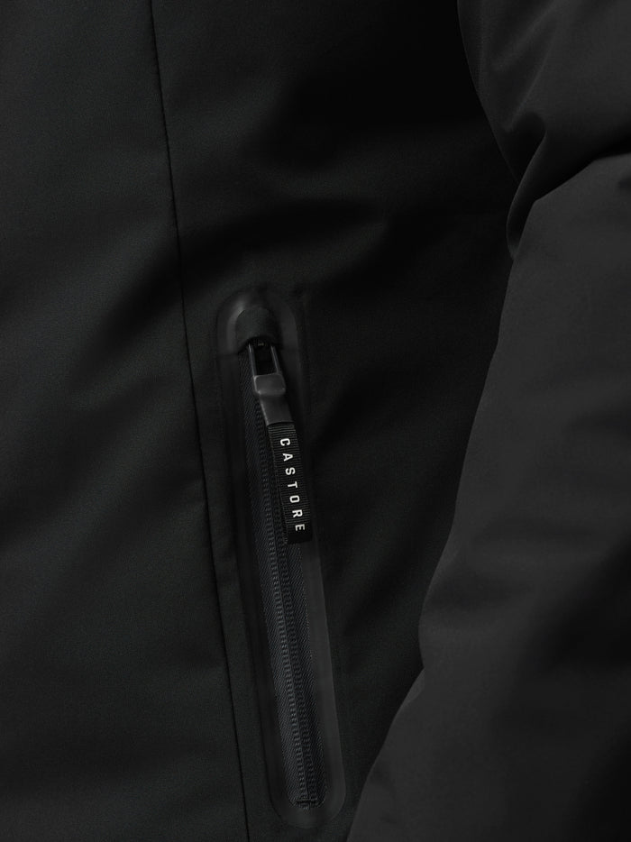 Close up of zipper detail on black longline jacket showing Castore branding