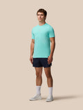 Male model wearing Zone Training T-Shirt in light aqua with navy shorts against a beige backdrop