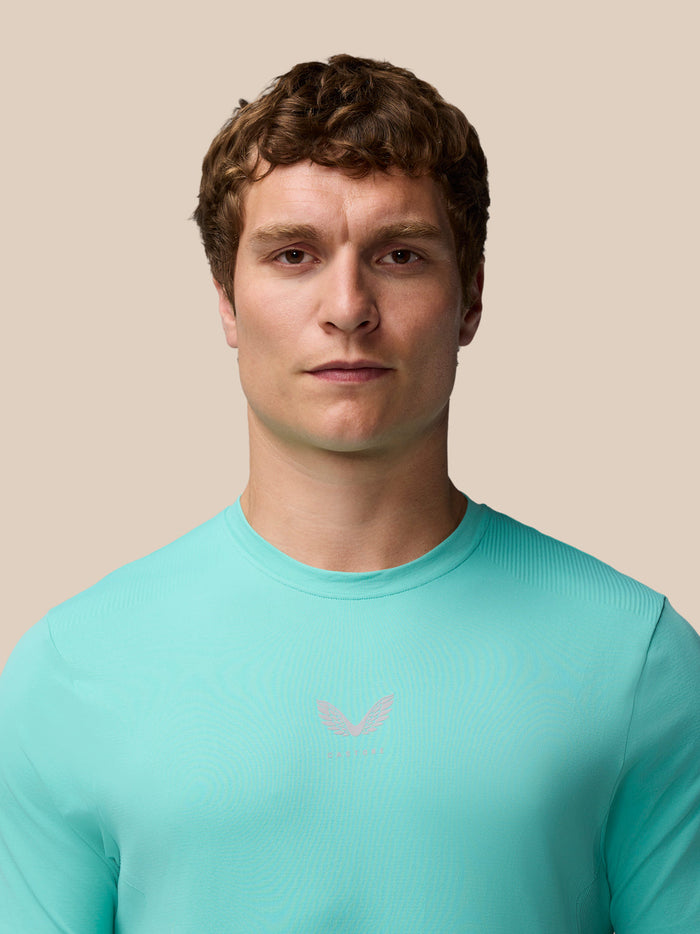 Close-up of a man wearing Zone Training T-Shirt in light aqua showing a subtle logo on the chest