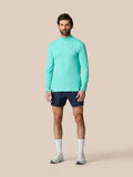 Full body shot of a man wearing a light aqua Zone Training 1/4 Zip Top with navy shorts.