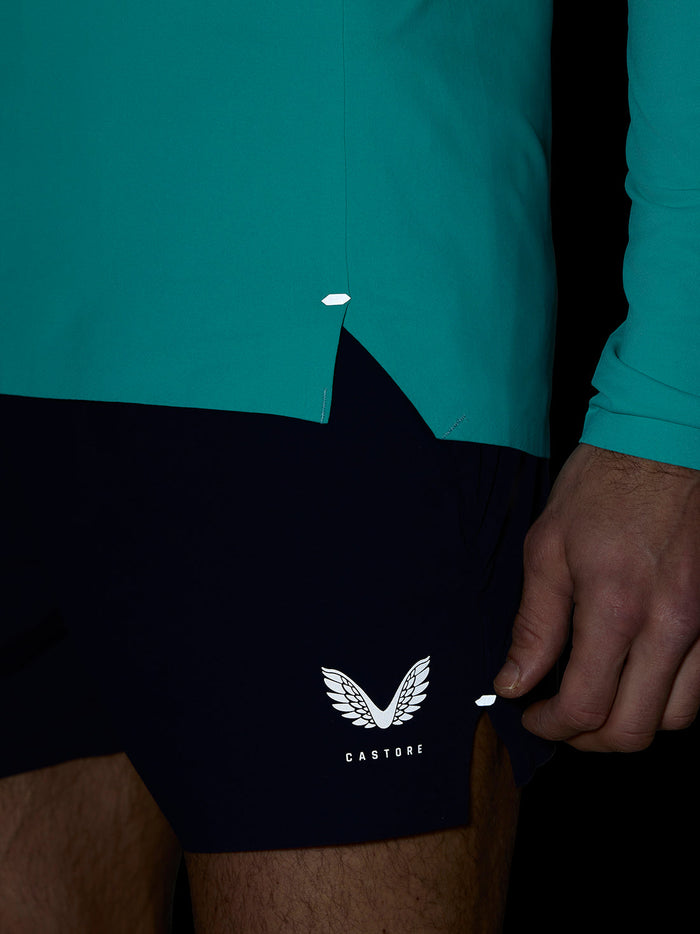 Close up of Zone Training 1/4 Zip Top in light aqua showing bonded hem and reflective branding.