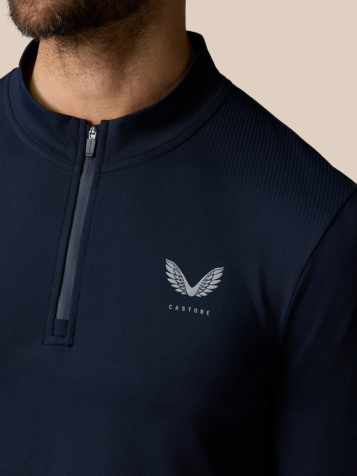 Close-up of navy Zone Training top collar with half zip and Castore logo on the chest.