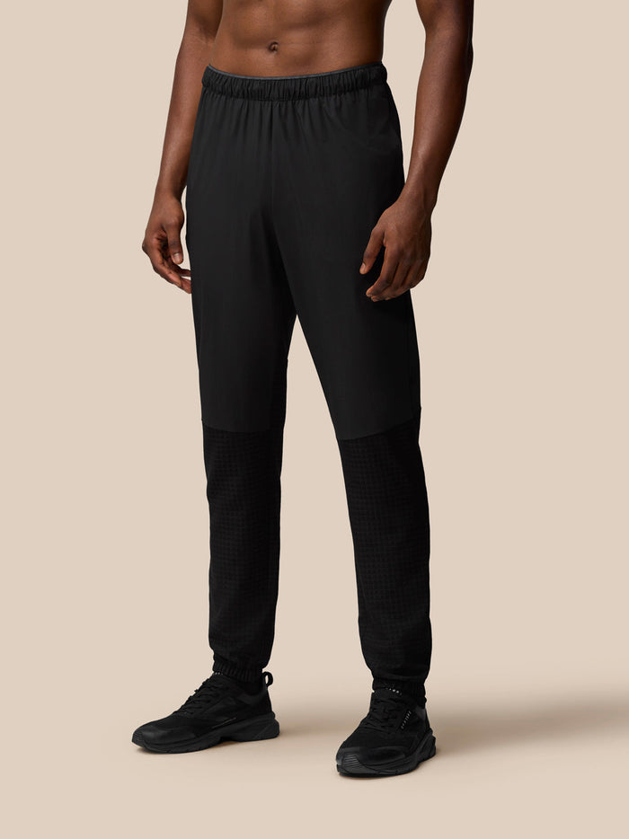 Male model wearing black Flex Winterised Woven Joggers with zipped pockets and ProTek water resistance