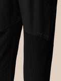 Close-up of black jogger leg showing CASTORE branding and a checkered textured panel.