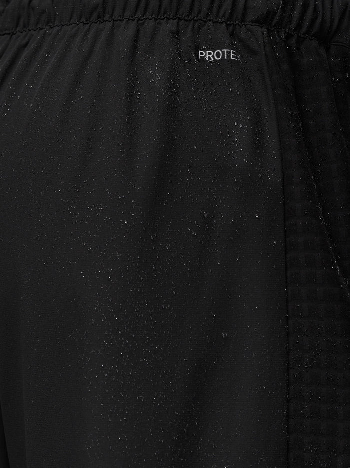Close-up of black ProTek treated jogger fabric with water droplets near the waistband.