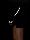 Close up of black Apex Training 6 inch shorts showing a bold white curved side stripe and Castore logo at the hem