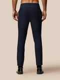 Rear view of a male model wearing midnight navy golf trousers, highlighting fit and back pocket.