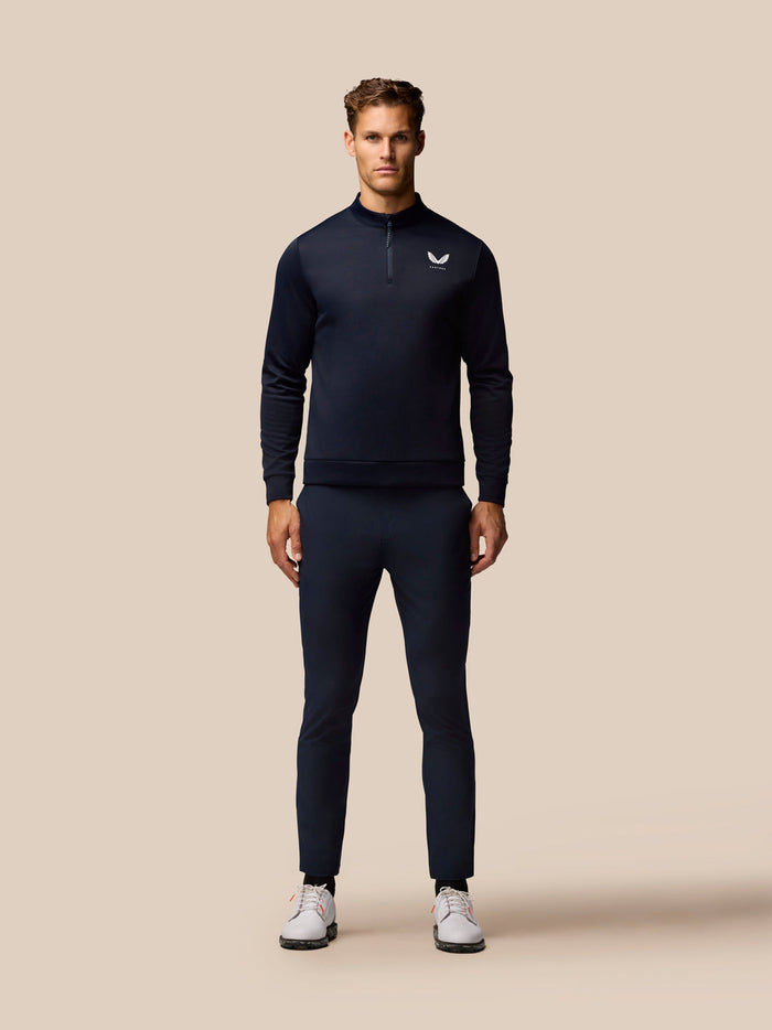 Full-body front view of male model in midnight navy golf outfit with zip neck top and matching trousers.