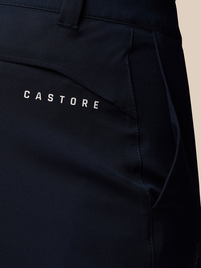 Close-up of midnight navy golf trousers showing back pocket with Castore branding.