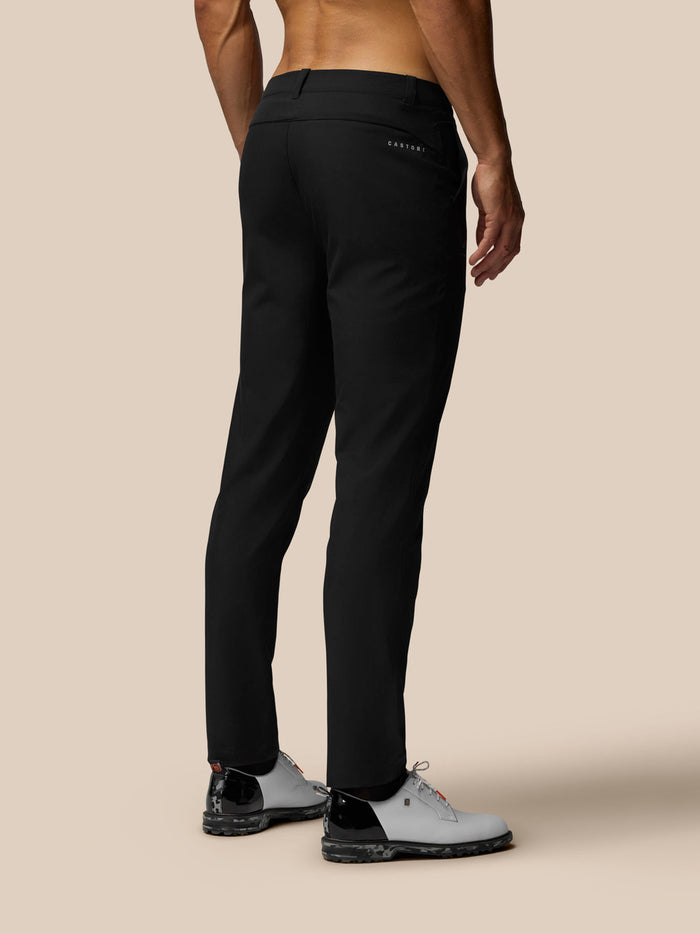 Back view of a man wearing black Golf Club Trousers with Castore branding on the rear pocket