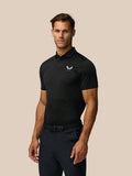 Male model wearing black Golf Pinnacle Pique Stripe Polo with subtle stripe pattern and Castore logo on chest