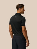 Back view of a man wearing the Golf Pinnacle Pique Stripe Polo in black with subtle stripes and Castore branding on the upper back.