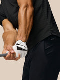 Rear three-quarter view of a man in a black striped golf polo showing Castore branding on the upper back.