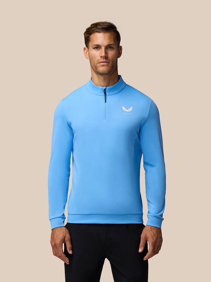 Male model wearing cool blue Golf Club Classic quarter zip top with funnel collar and chest logo