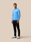 Full-body view of a man wearing the Golf Club Classic Quarter Zip Top in cool blue with center front zip and Castore logo