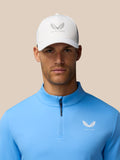 Front view of man wearing blue Club Classic quarter zip top and white cap with Castore logo on chest