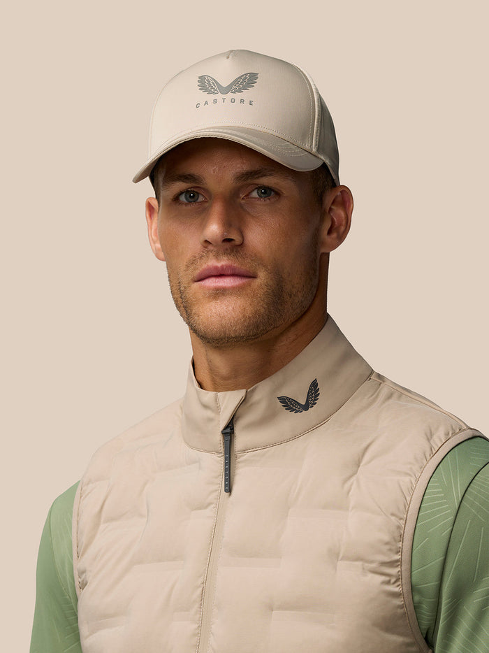 Man wearing Mushroom Golf Pinnacle Gilet with funnel collar and full zip against a neutral background