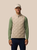 Man wearing Mushroom Golf Pinnacle Gilet with cap, showcasing quilted front panel and collar logo