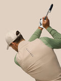 Back three-quarter view of a man wearing Mushroom Golf Pinnacle gilet while swinging a golf club