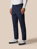Male model wearing midnight navy Golf Pinnacle Winter Trousers with a belt and white long sleeve top.
