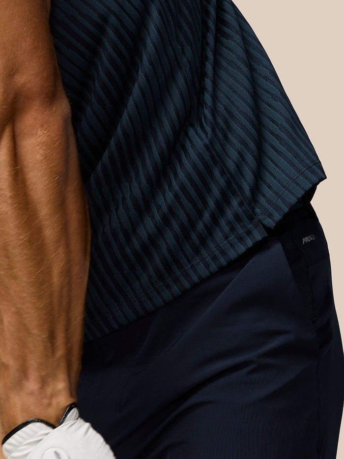 Close up of the navy striped knit fabric from the Golf Pinnacle Glow Polo showing the textured pattern and sleeve detail