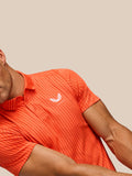 Close-up detail of Golf Pinnacle Glow Polo Bright Orange showing striped knit pattern and left chest logo.