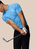 Golfer in a light blue Golf Club Glow Printed Polo mid swing with black pants and golf club in hand