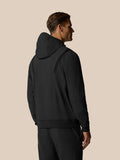 Back view of a man in a black Golf Pinnacle Performance Hoodie with hood down and ribbed shoulder panels