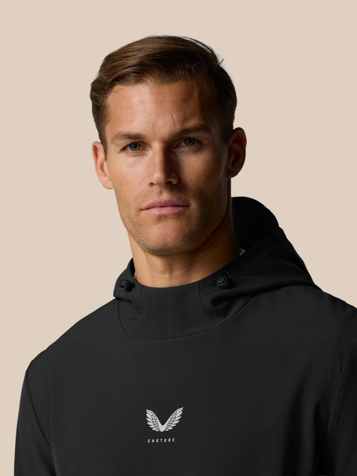 Close-up of the Castore wing logo and brand name on the chest of the black Golf Pinnacle Performance Hoodie.