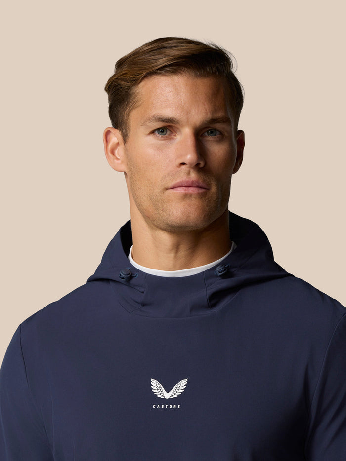 Close-up of a male model in midnight navy Golf Pinnacle Performance Hoodie featuring chest logo and hood.
