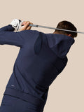 Golfer wearing Midnight Navy Golf Pinnacle Performance Hoodie mid swing with a club
