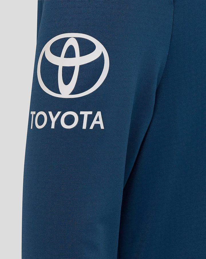 Close-up of sleeve showing bold Toyota logo on blue midlayer fabric.
