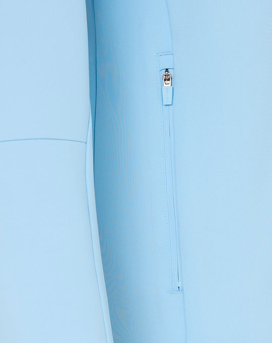 Close-up of light blue hoodie side zipper pocket with pull tag.