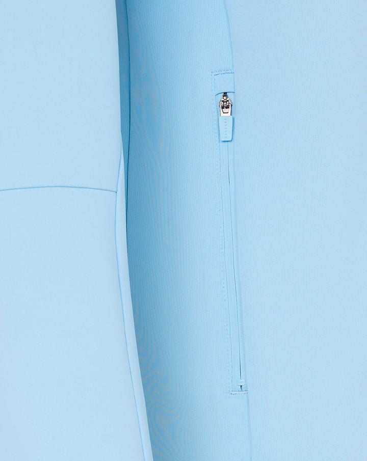 Close-up of light blue hoodie side zipper pocket with pull tag.