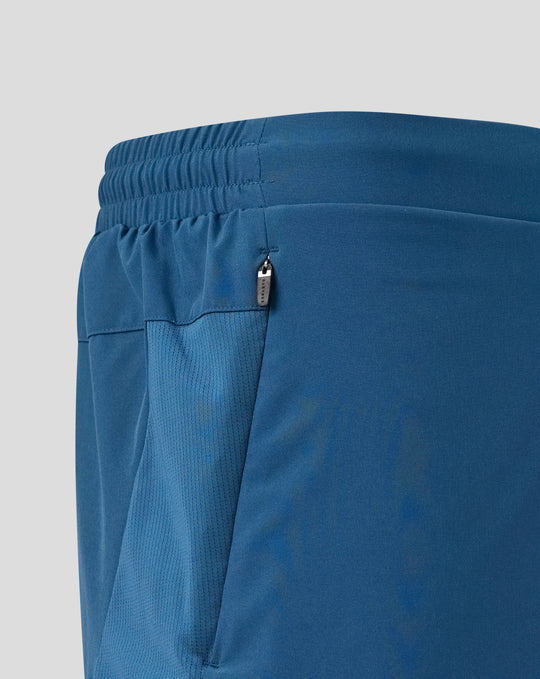 Close up of blue training shorts waistband with zip pocket and side panel