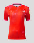 Welsh Fire women's 2026 short sleeve stretch jersey in red with pink trim, bold geometric pattern, crest and sponsor logos.