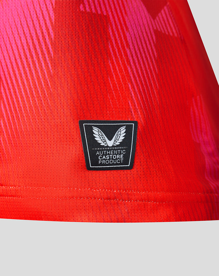 Close up of red Welsh Fire jersey fabric with Authentic Castore Product badge near the hem