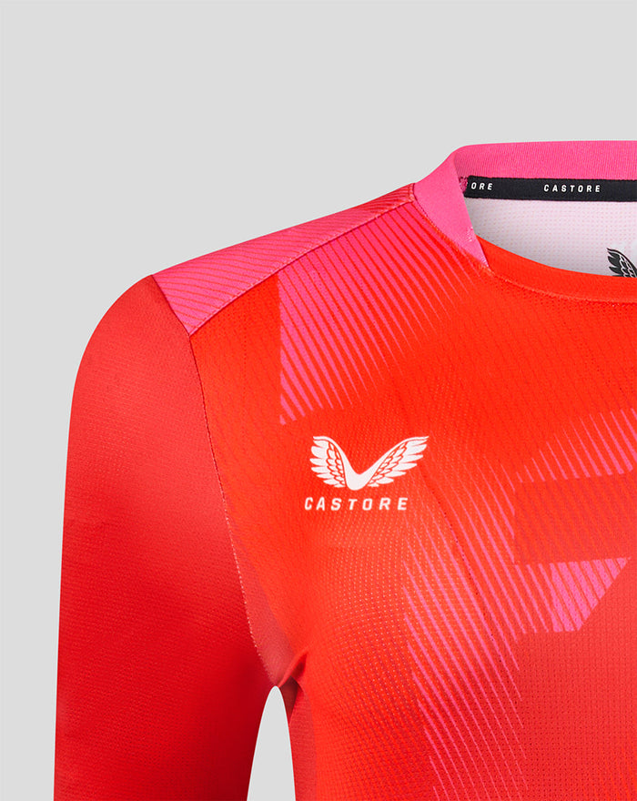 Shoulder to chest view of red Welsh Fire jersey with Castore logo and pink geometric print