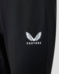 Close-up of white wing logo with Castore text on black pants