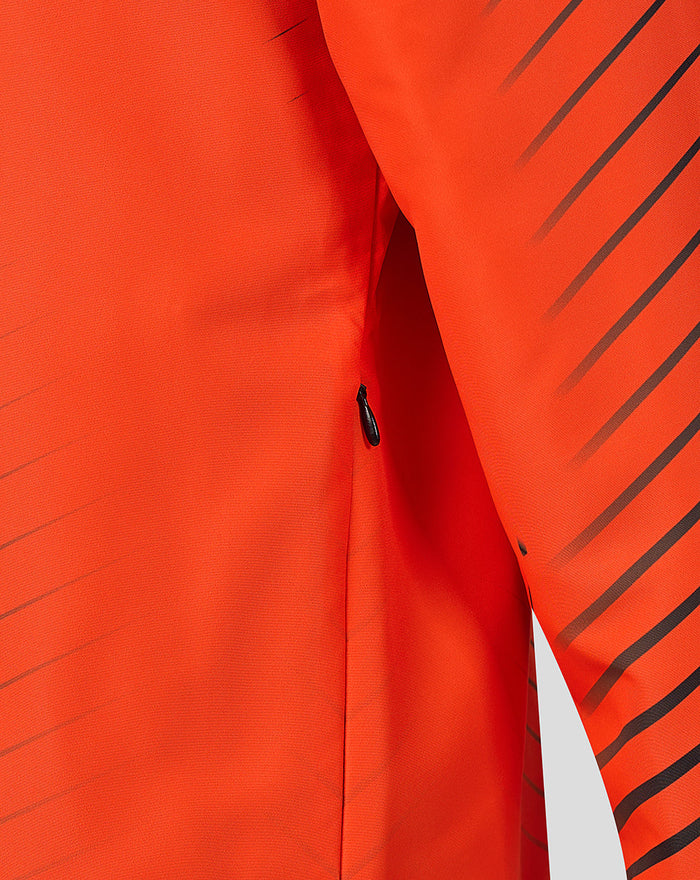 Detail of side zip pocket on bright orange jacket with diagonal stripes.