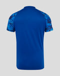 Back view of blue ODI cricket shirt with solid body and camo patterned raglan sleeves.