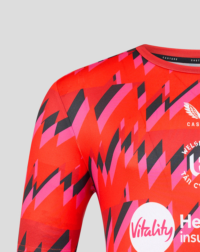 Close up of red pink geometric pattern on Welsh Fire training T shirt with crest and Vitality sponsor logos.