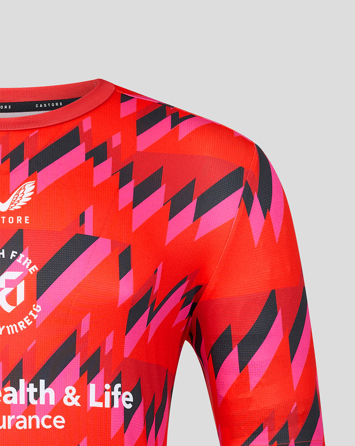 Close up of bold red and pink geometric print across the chest and shoulder of the Welsh Fire training T shirt.