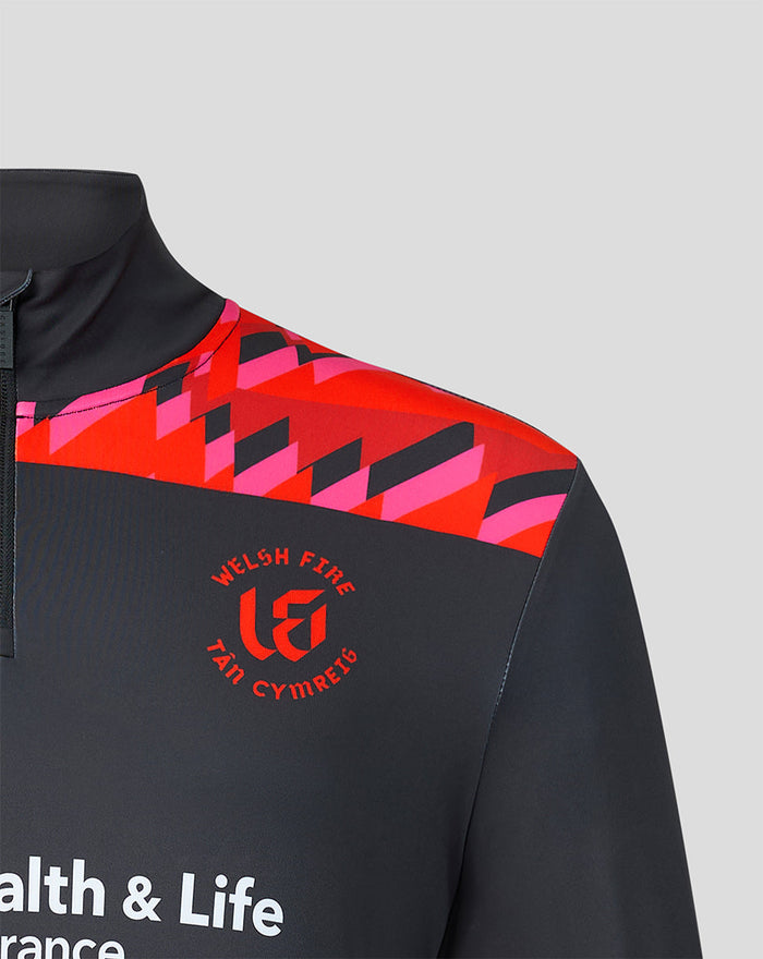 Close up of shoulder area showing red geometric design and Welsh Fire crest on a dark quarter zip top