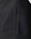 Close up of the zip and seam on a dark Welsh Fire woven pre match jacket