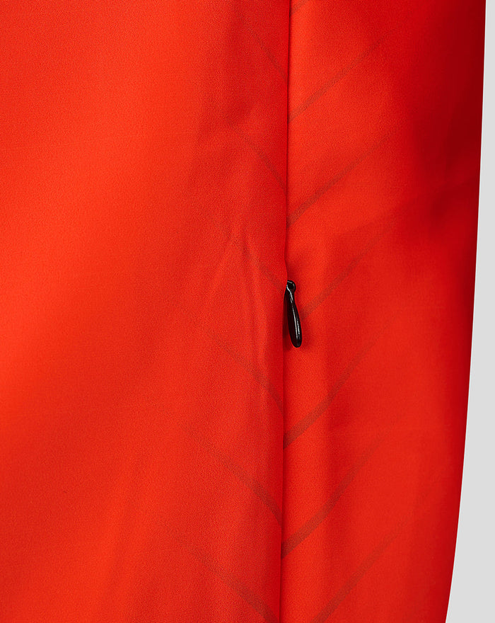 Close up of orange jacket fabric with a vertical zipper and diagonal stitching details